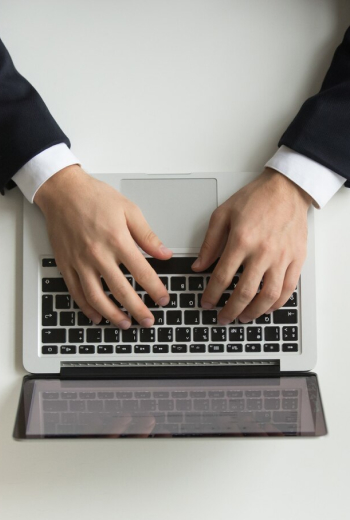 Profissional analisando documentos no computador para iniciar abertura de empresa